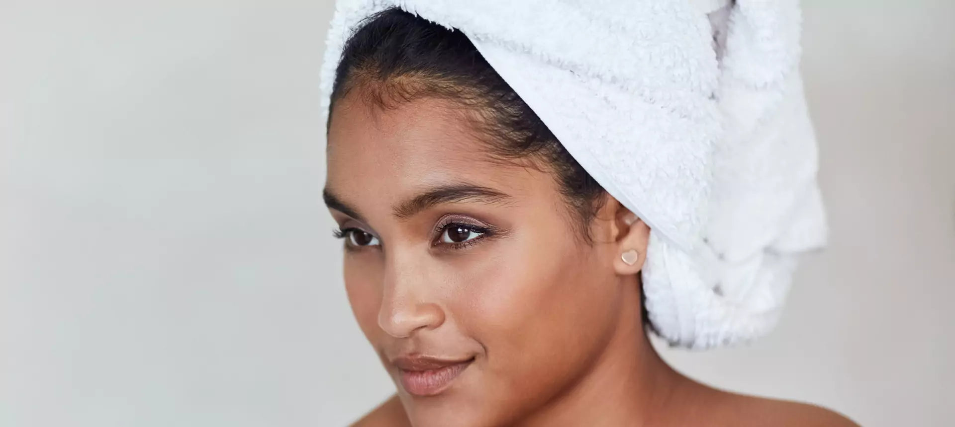 Ung kvinne med håndkle på hodet