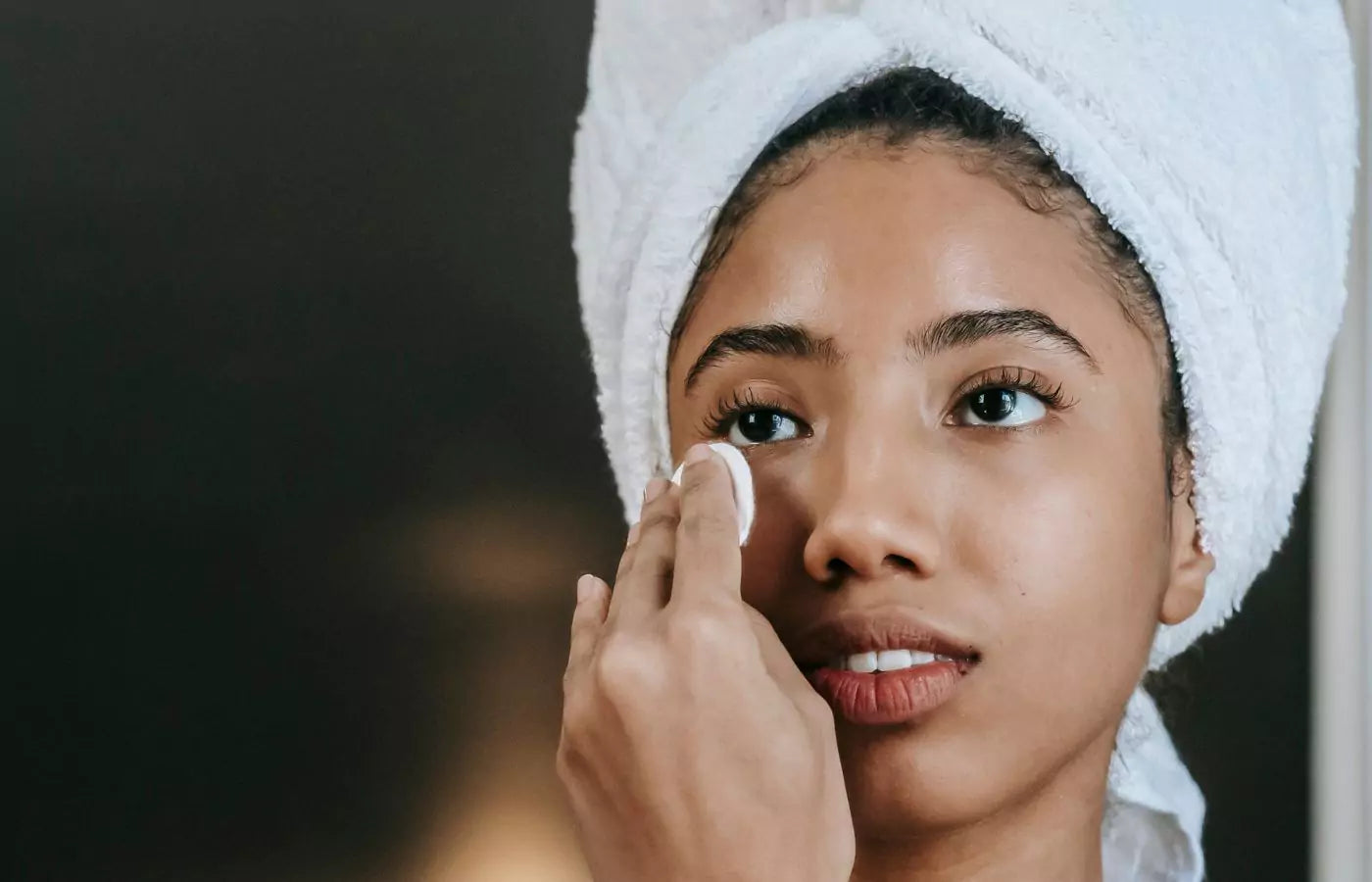 Ung kvinner påfører toner i ansiktet 